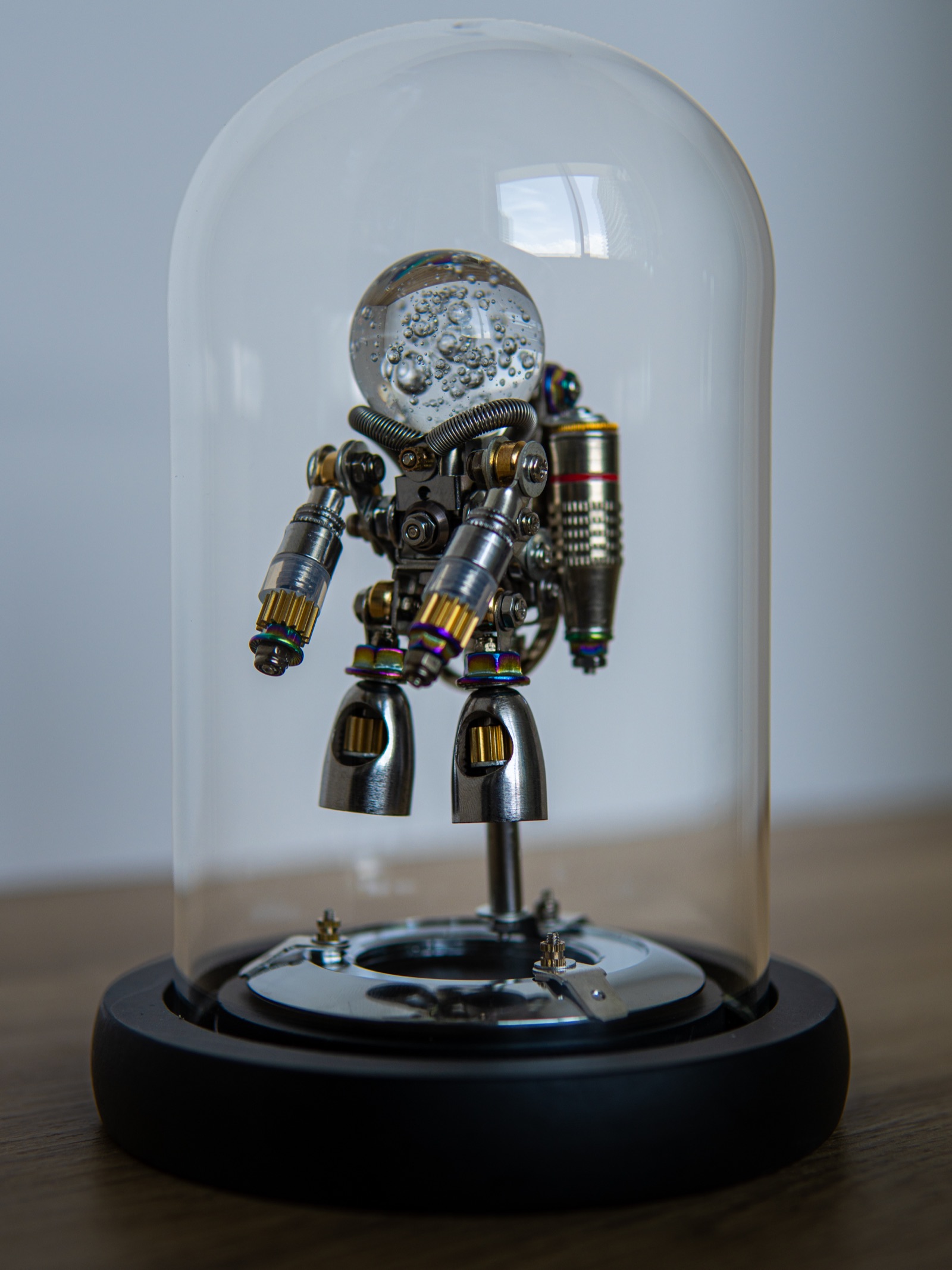 Nebula Astronaut figure displayed under its glass dome on a wooden table